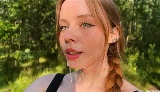 Блонда с зелеными глазами сосет в лесу